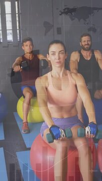 Coach offering weights, center woman leading class raising dumbbells on stability balls for fitness