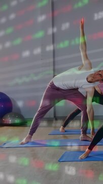Vertical video: Man shifting weight reaching yoga pose on blue mats with ticker overlay for balance