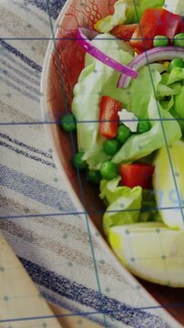 Vertical video: Camera panning right, zooming on bowl, showing ramekin and grid overlay for food