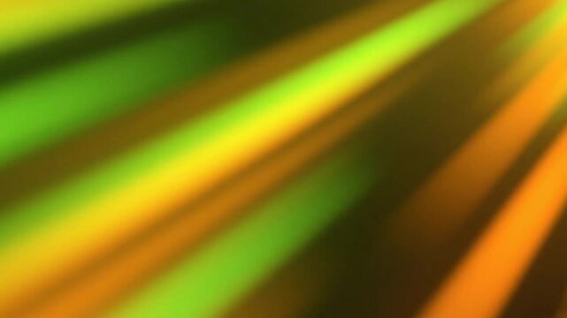 Abstract background of blurred yellow orange and green rays of light shining from the upper right corner