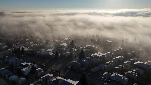 Aerial view of a residential community on a foggy morning. 