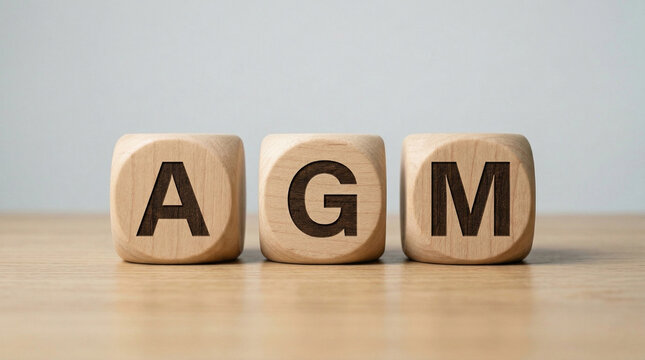agm text on wooden blocks placed on clean surface with minimal background for corporate meeting and business concept