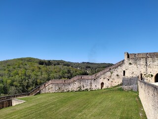 Fototapeta premium Ancient stone fortification wall standing tall against a bright clear blue summer sky in france