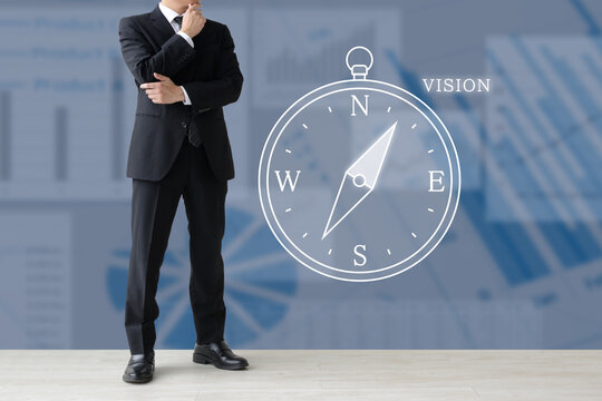 会社や企業のビジョンや経営の方向性を考えるビジネスマンと方位磁針