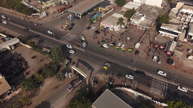 High Angle View of Busy T-Junction Traffic with Auto Rickshaws and Petrol Pump Station in India.
