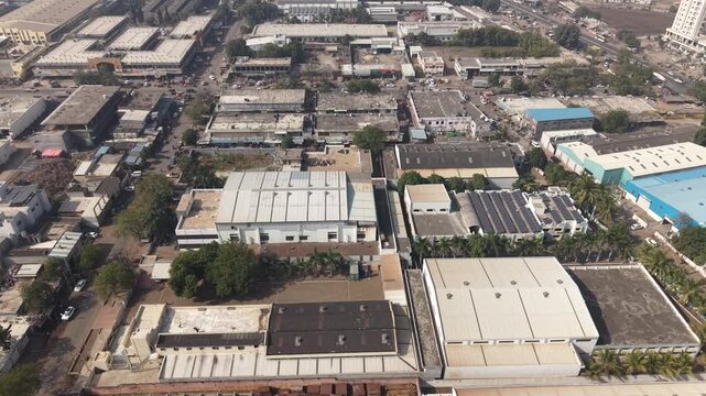 Densely Packed Industrial Sector Showing Diverse Factory Roof Designs and Roads.