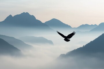 Obraz premium Eagle silhouette soaring over valleys filled with fog and haze, depicting freedom, power, and nature's beauty