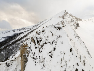 Snow Covered Mountain Ridge in British Columbia, Canada With Dramatic Winter Peaks and Alpine Forest © edb3_16