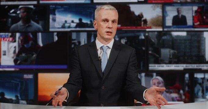 Confident Male Reporter in Formal Wear Presenting Story, in Studio With Video Wall Displaying Military Action, Disaster Relief, and Political Interviews. Broadcast Journalism, Crisis Media Reporting.