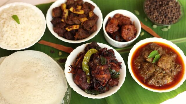 Top view of non veg sadhya sadya white rice appam chicken fry, beef fry,  fish curry. Kerala special Indian food. Fish fry beef pork cutlet. Asian cuisine. Kerala, Goan fish curry clay pot. 