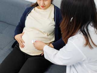 Asian happy young pregnant woman sit checkup female doctor with stethoscope in maternity hospital...