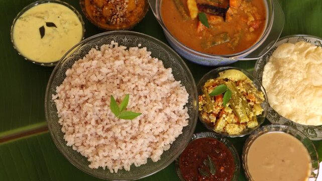 Traditional Onam Vishu sadhya rice Sambar, Rasam, parippu dal curry ghee Pappadom Payasam on banana leaf Onam Pongal Diwali festival vegetarian food Kerala Tamil Nadu South India. 4k video footage