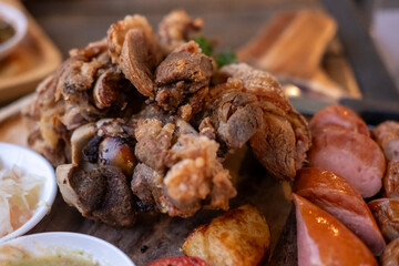Fototapeta premium Crispy German pork knuckle with sausage served in the restaurant