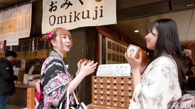Two Japanese Women in Kimonos Shaking Omikuji Fortune Boxes at Shrine