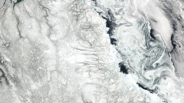 Top view on snowy region in winter with cloud formation. Camera is moving backward and left. Animation based on image by NASA