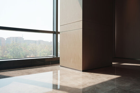 Modern office interior with floor-to-ceiling window, sunbeam column, and structural pillar