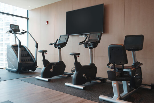 Modern fitness gym featuring multiple exercise bikes and elliptical machines indoors
