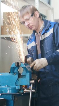 Mechanic in garage at work - circular saw sparkles during worker grinding metal detail hamstrung automobile repairing