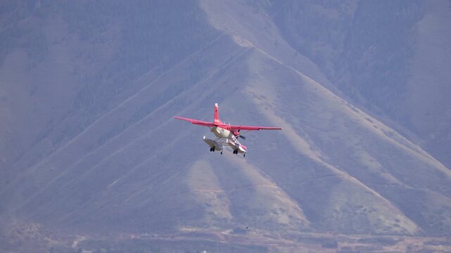 A floatplane flying in to land a Provo airport in slow motion viewing the scenic mountains in the background.