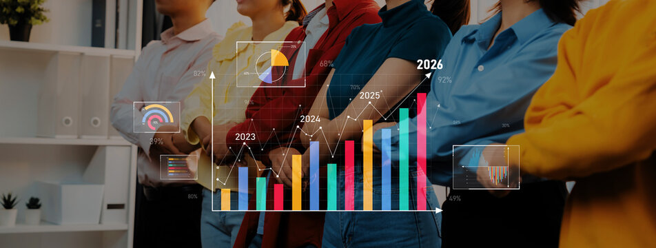 A dynamic scene showing a diverse group of business professionals observing colorful growth charts and data projections on a futuristic screen in a modern office setting. Trope