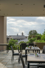 Fototapeta premium South Africa,Golf Resort,Outdoor dining area with tables and chairs overlooking a garden and rooftops under a cloudy sky