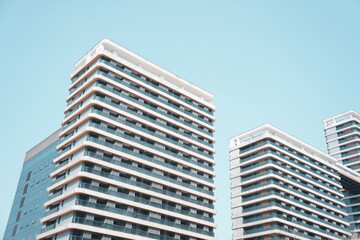 Obraz premium Modern high-rise residential buildings captured from a low angle against a clear blue sky