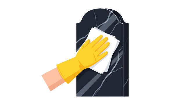 A person wearing a protective yellow rubber glove carefully polishes the surface of a dark marble headstone using a soft white cloth on white background.