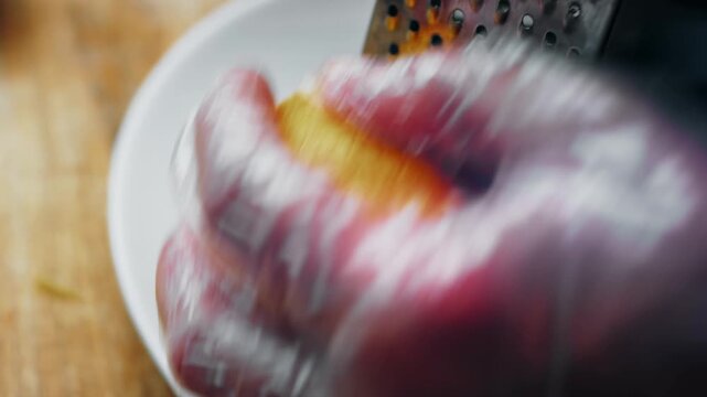 Lemon peel being finely grated into small strips