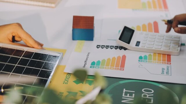 Business executives collaborating on environmental sustainability strategy utilizing renewable energy solutions to achieve net zero targets in corporate meeting.