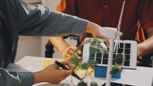 Business executives collaborating on environmental sustainability strategy utilizing renewable energy solutions to achieve net zero targets in corporate meeting.