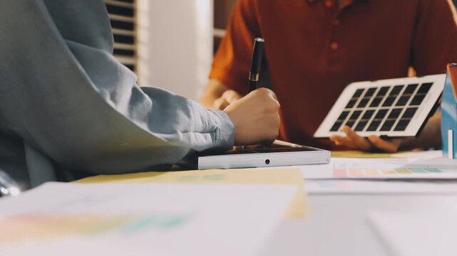 Business executives collaborating on environmental sustainability strategy utilizing renewable energy solutions to achieve net zero targets in corporate meeting.