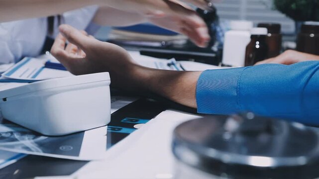 Doctor checking blood pressure of a patient, he is measuring pulses with a sphygmomanometer, hands close up