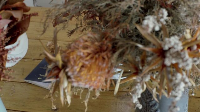 Australian passport surrounded by dried banksia and native Australian flowers, filmed with a smooth cinematic dolly movement. Visual for Australian travel, tourism, national identity, immigration 