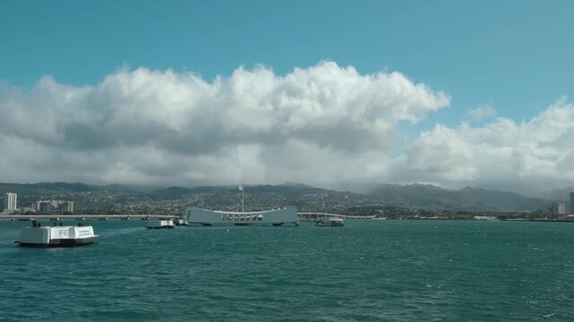 USS Arizona Memorial. at USS Missouri (BB-63) - Battleship Museum in Pearl Harbor National Memorial. Honolulu, Ohau, Hawaii.  In the distance is the Koʻolau Range