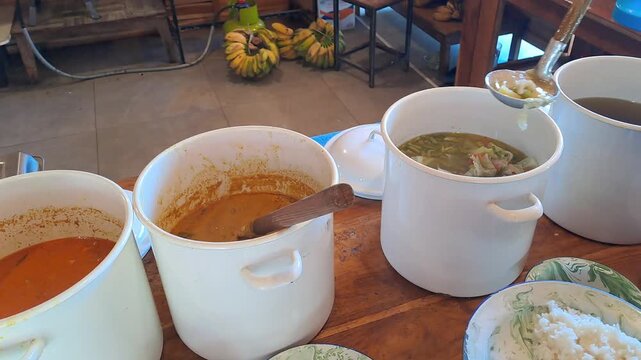 PAMEKASAN, INDONESIA - DECEMBER 17, 2025: Handheld footage inside a traditional Javanese joglo-style restaurant, showcasing authentic Indonesian cuisine, local vegetables, fish dishes, sambal, lalapan