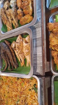PAMEKASAN, INDONESIA - DECEMBER 17, 2025: Handheld footage inside a traditional Javanese joglo-style restaurant, showcasing authentic Indonesian cuisine, local vegetables, fish dishes, sambal, lalapan