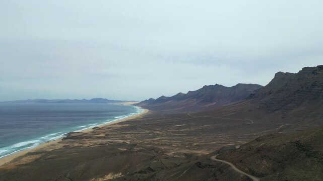 Cofete - Fuerteventura - Wyspy Kanaryjskie - Hiszpania - piękna długa plaża połączona z g&oacute;rami, duże fale, szeroka plaża, piękne widoki, nagrane dronem