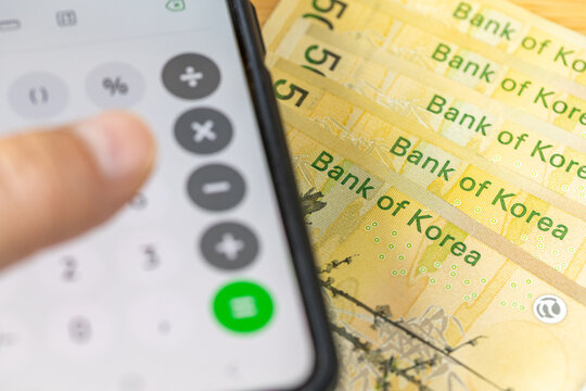 South Korean money and a calculator in a phone. Financial calculations. Business and economic concept. Close up