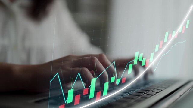 A close-up view of hands typing on a laptop, complemented by a digital graph overlay showing financial growth and market trends in a modern workspace environment. Copula