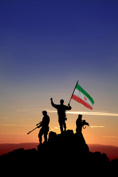 Silhouettes of anonymous soldiers with Iran flag on mountain at sunset, victory, teamwork, war concept, copy space.