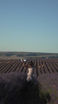 Girl running airplane toy in vast lavender field dreaming of travel and freedom Vertical video