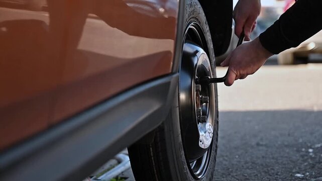 Vehicle supported by a jack during wheel replacement, illustrating the tyre changing process.