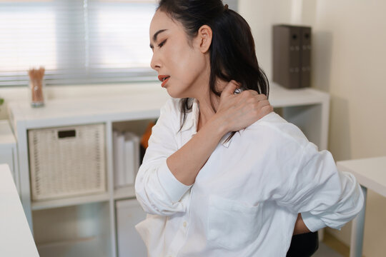 Office worker experiencing neck and back pain from prolonged computer work
