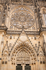 Obraz premium Ornate Gothic facade of St. Vitus Cathedral in Prague, Czech Republic. Close-up of the Great Rose Window and stone carvings on the entrance.