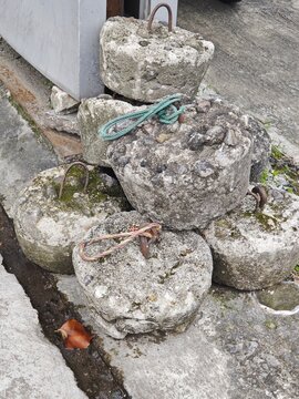 Heavy Concrete Counterweights for Securing Tarpaulins on a Sidewalk.