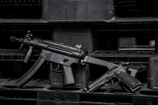 Modern submachine gun and semi-auto pistol on black back