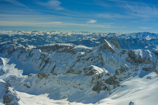 Snow covered mountain peaks under clear blue sky create breathtaking alpine landscape. rugged terrain and distant mountain ranges evoke sense of adventure and tranquility