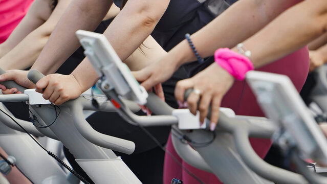 Close up of a group of women exercising on stationary bikes in a fitness class