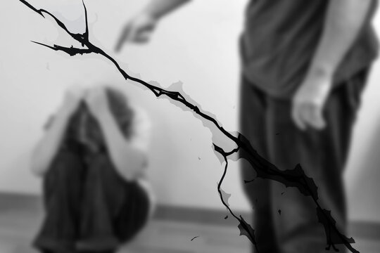 Blurred Black and white scene with cracked glass foreground as a man confronts a scared woman, symbolizing abuse, coercive control, fear, trauma and family conflict.