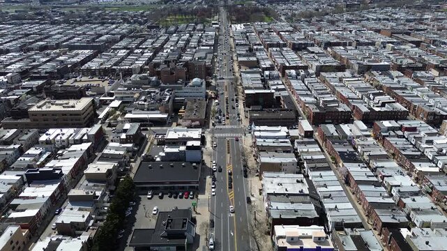 Industrial edge transition near S 11th St, Oregon Ave blends residential density with nearby warehouse structures. Light roof coatings, brick repetition, warm daylight unify textures, Philly, PA